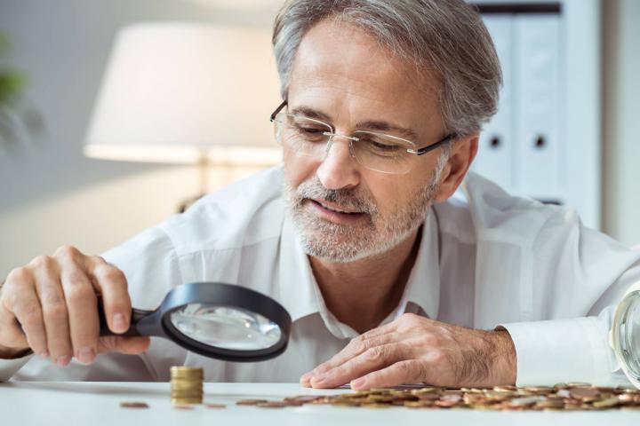 Un experto analiza monedas para valorar sus valores actuales