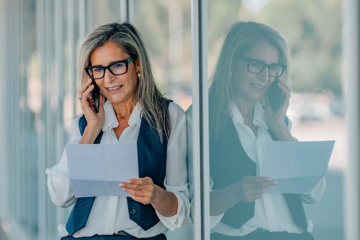 Una empresaria habla por teléfono en su oficina.