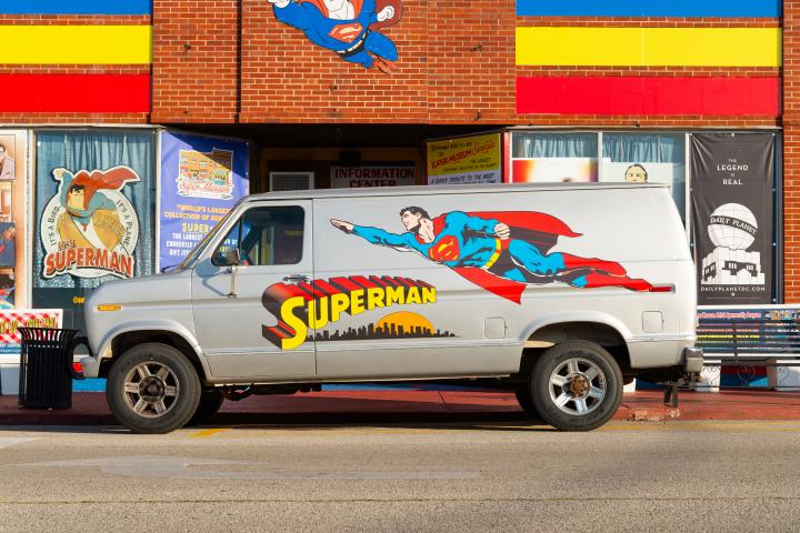 Una furgoneta con un Superman dibujado enfrente de una tienda de artículos del superhéroe