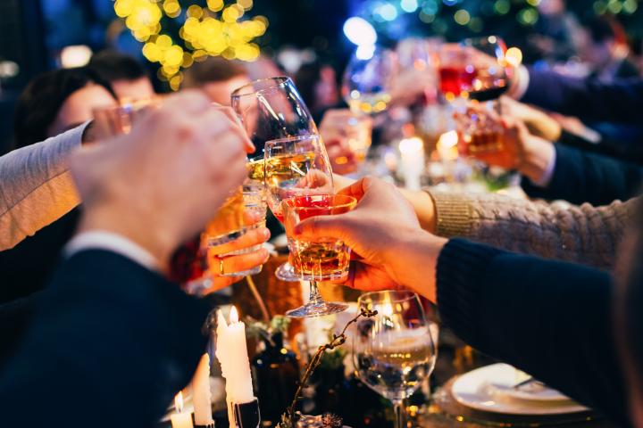Personas brindando con copas en una cena.