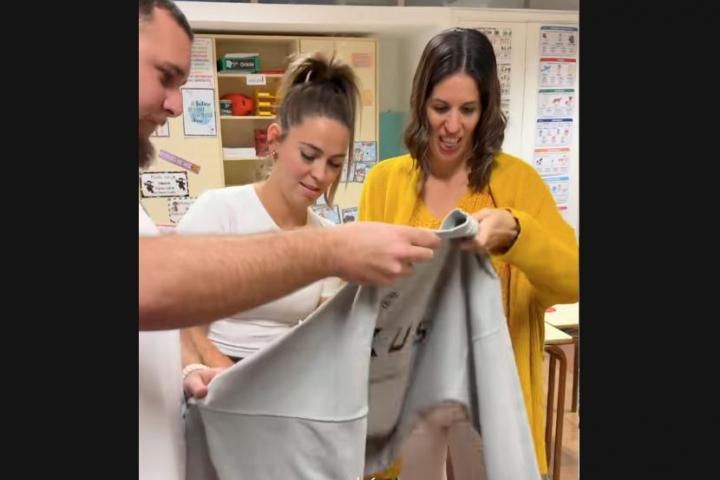 Un grupo de profesores revisando la chuleta de un alumno.