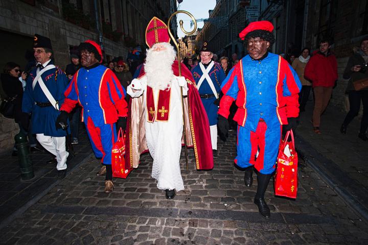 San Nicolás y sus dos ayudantes, vestidos tradicionalmente como Pedro el Negro, caminan por Bruselas durante el desfile anual, en 2016.