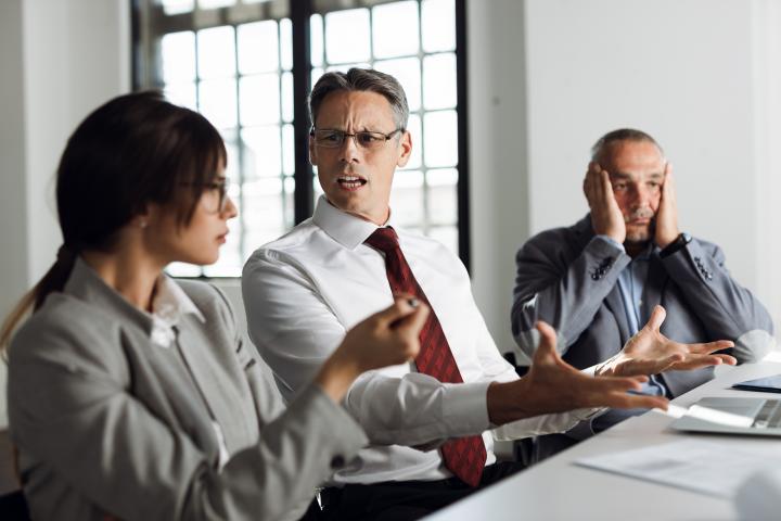 Tres trabajadores en la oficina del jefe