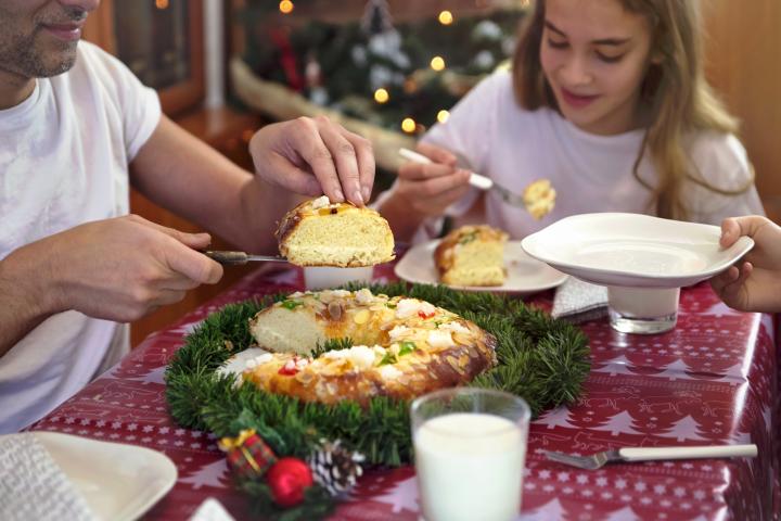 Una familia comiendo roscón de Reyes.