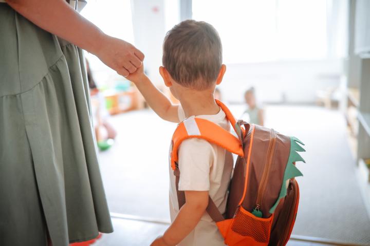 Un niño de la mano de su madre