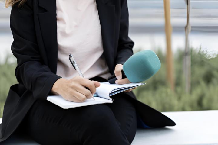 Una periodista anotando cosas en su cuaderno