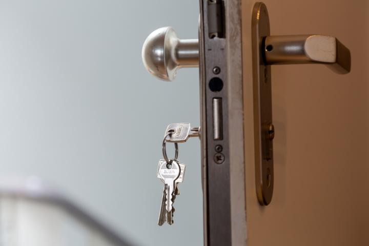 Puerta entre abierta con la llave en la cerradura.