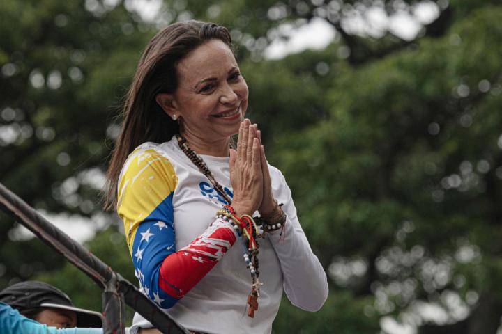 La líder opositora María Corina Machado saluda sus partidarios desde un camión durante el mitin de inicio de la campaña presidencial de Edmundo González Urrutia, el 4 de julio de 2024, en Caracas.