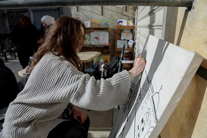 Una mujer dibujando en un lienzo en blanco