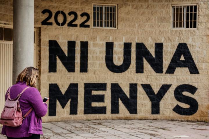 Una mujer pasa junto a un muro que dice "Ni una menos", en Valencia, en 2022.