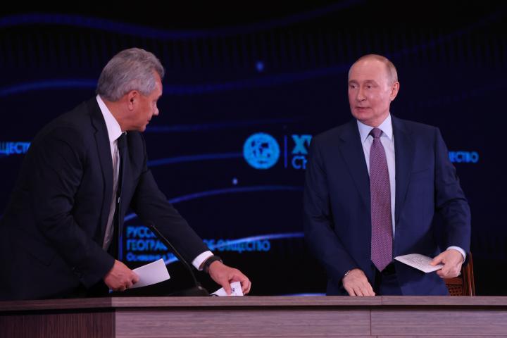 El presidente ruso, Vladímir Putin (d), conversa con el secretario del Consejo de Estado, Serguéi Shoigu (i), durante el Congreso de la Sociedad Geográfica Rusa, el 23 de octubre de 2025 en Moscú, Rusia. EE. UU.