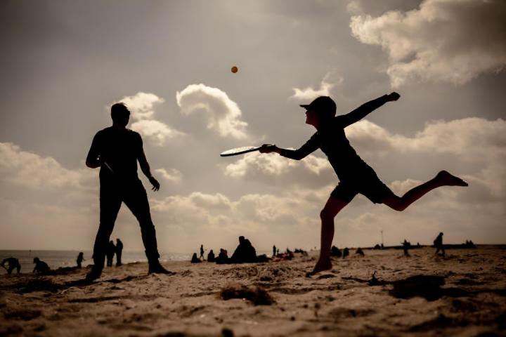Un padre y su hijo jugando a las palas en una playa de Alemania.