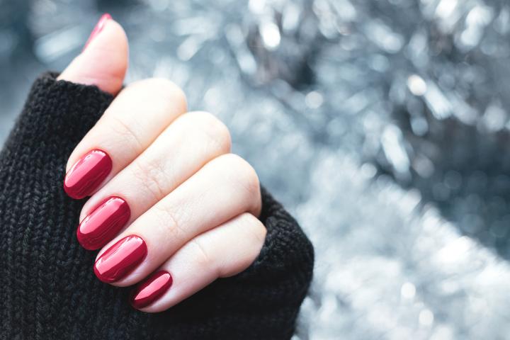 Una mujer enseña su manicura navideña