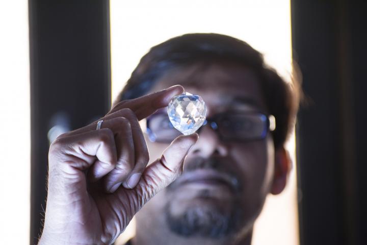 Tasador sostiene un diamante natural de gran tamaño durante su evaluación