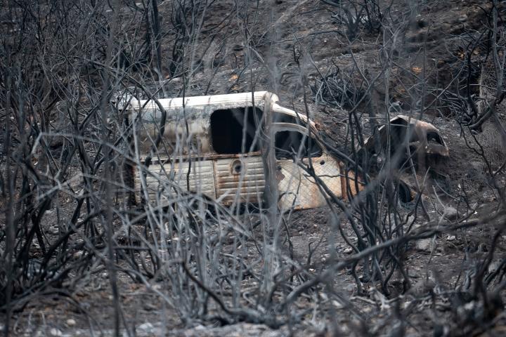 Una furgoneta quemada, entre un campo arrasado por las llamas en León.