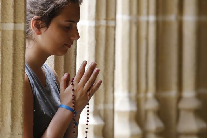 Una joven reza en una iglesia