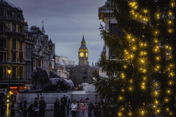 alt="alt="Una vista impresionante de Trafalgar Square en un día de Navidad, donde un majestuoso árbol de Navidad iluminado cobra protagonismo. La plaza está cubierta por una capa de nieve pura que crea una atmósfera navideña mágica. Al fondo, el icónico Big Ben o la Torre del Reloj de Elizabeth y las majestuosas estatuas de leones adornan la escena, convirtiéndola en un verdadero paraíso invernal. Trafalgar Square, Blanca Navidad, Árbol de Navidad, Big Ben, Día nevado, Nevada, Paraíso invernal, Temporada navideña, Árbol iluminado, Plaza nevada, Monumentos de Londres, Vista majestuosa, Estatuas de leones, Atmósfera mágica""