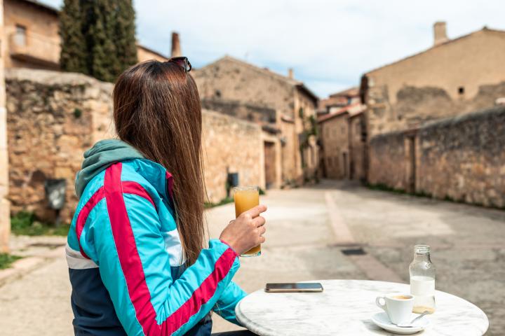 Una joven tomando algo en el bar de un pueblo.