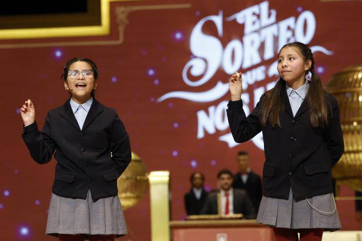 Alba Yadira Machaca e Italy Andrea Blanco cantan el número agraciado con el premio gordo del Sorteo de la Lotería de Navidad.