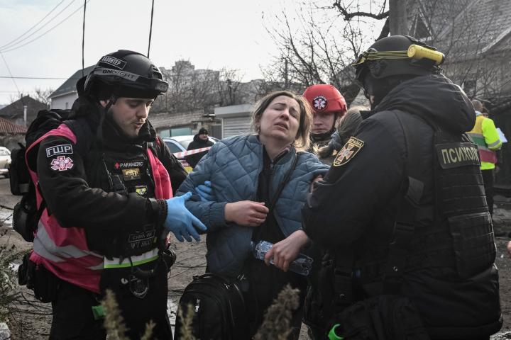 Un psicólogo de emergencia y un paramédico ayudan a un residente en el lugar de un ataque aéreo ruso, en medio del ataque de Rusia a Ucrania, en Zaporizhia, el 19 de diciembre de 2025.