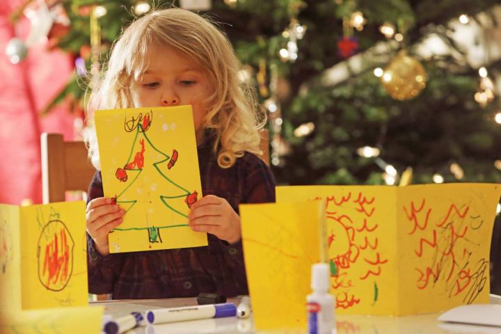 Joven haciendo tarjetas de Navidad caseras