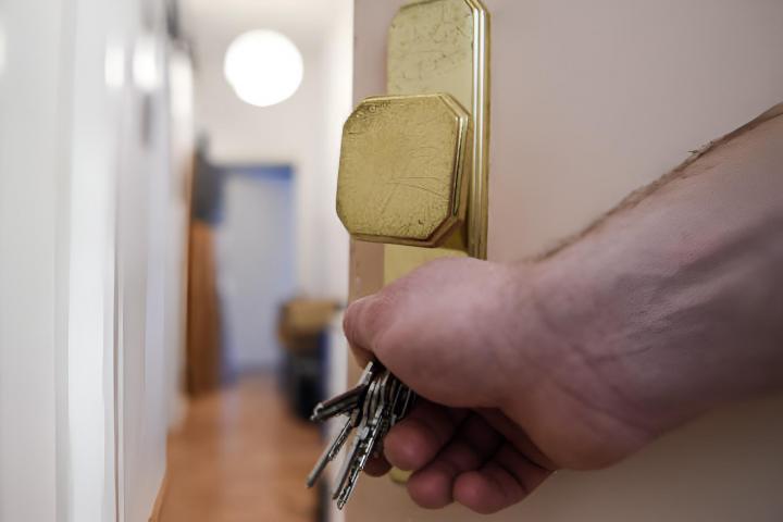 Un hombre abriendo la puerta de una vivienda.