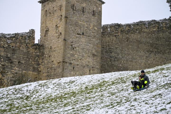 Padre e hijo disfrutan de la nieve caída en Morella