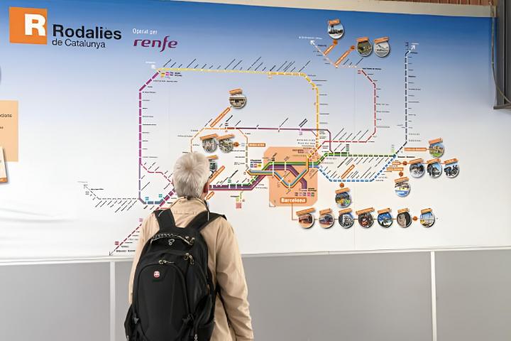 Un hombre mirando el mapa de la red ferroviaria de Rodalies de Catalunya servicios operados por RENFE