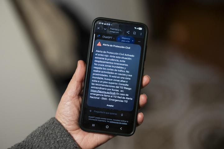 Una persona muestra el mensaje de Protección Civil que ha recibido en su móvil.