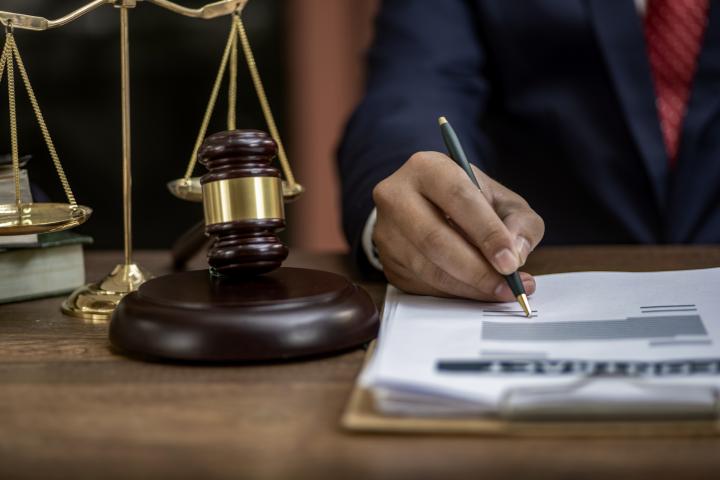 Hombre sentado en un escritorio junto al mazo judicial.