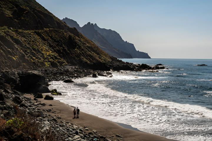 Una pareja paseando en la playa de Roque de las Bodegas, en la costa norte de Tenerife.