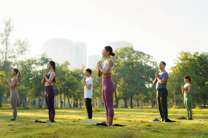 Varias personas haciendo yoga en un parque, en una imagen de archivo