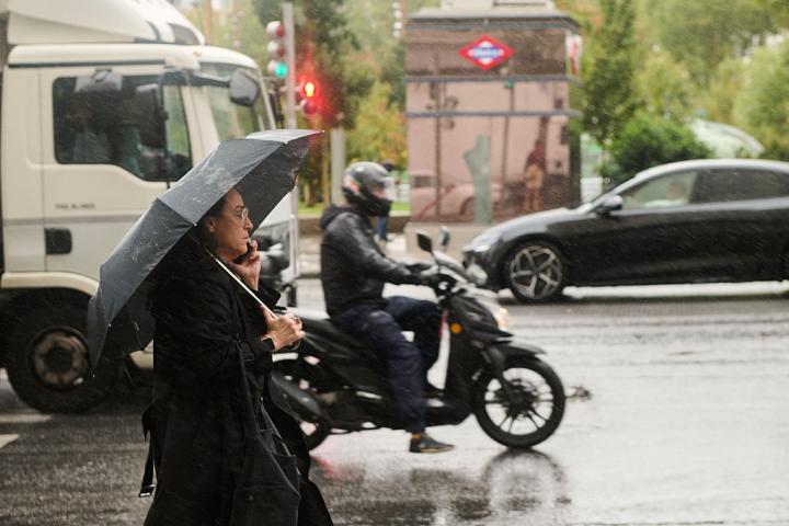 Una persona pasea bajo el paraguas en un día de lluvia en Madrid