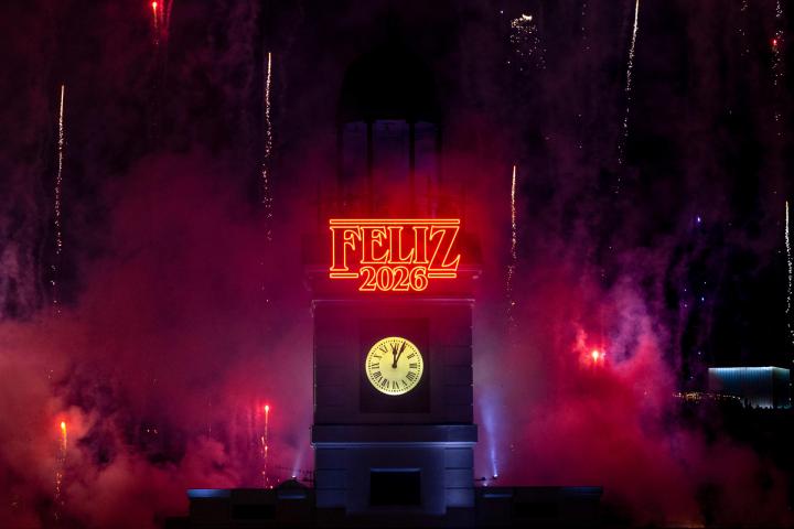 Fotografía que muestra al reloj de la Puerta del Sol rodeado de fuegos artificiales durante la celebración de las Campanadas de Nochevieja este jueves, en Madrid