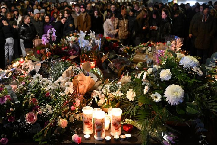 Flores y velas durante una vigilia en Crans-Montana tras el incendio mortal en un local nocturno de la estación alpina suiza.