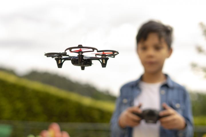 alt="alt="Primer plano de un niño volando un dron en el parque""
