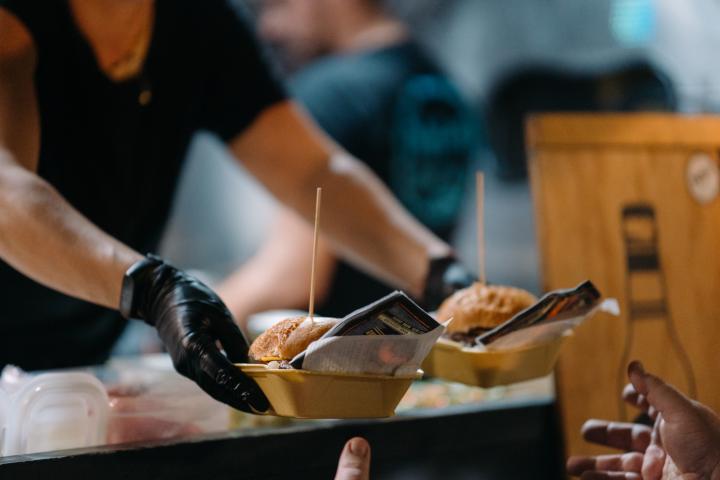Una persona sirviendo hamburguesas en un food truck, en una imagen de archivo