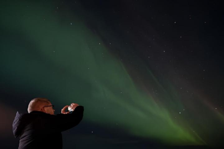 Una persona tomando fotografías de la aurora boreal en la ciudad de Hamar en Noruega.