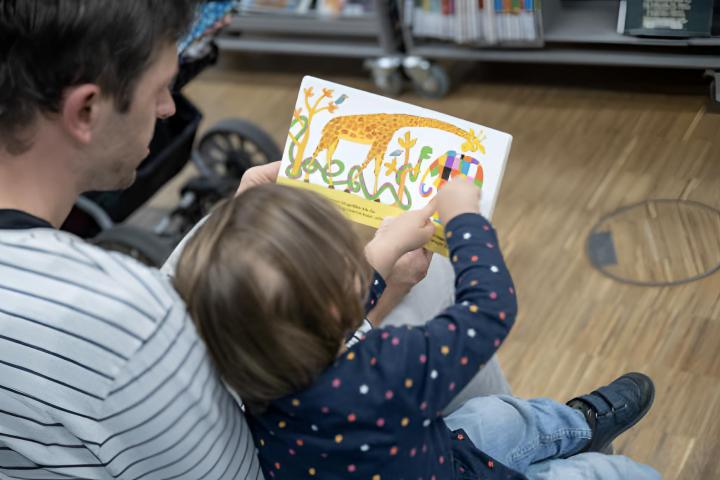 Un padre lee un libro con su hija