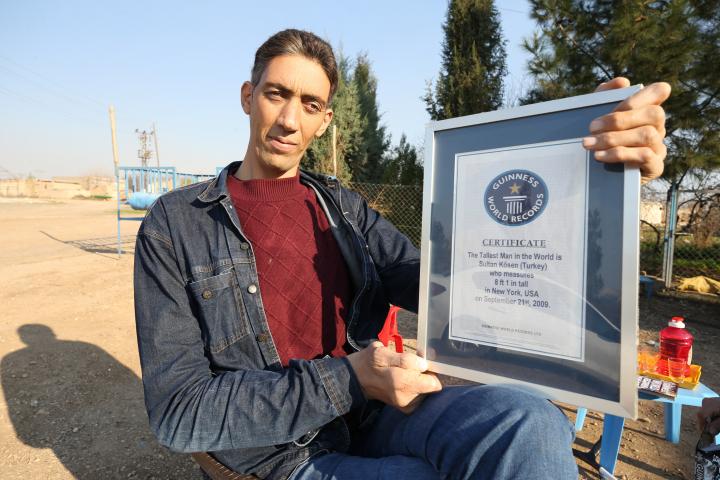 Sultan Kosen, posando con su placa del récord Guinness como el hombre más alto del mundo.