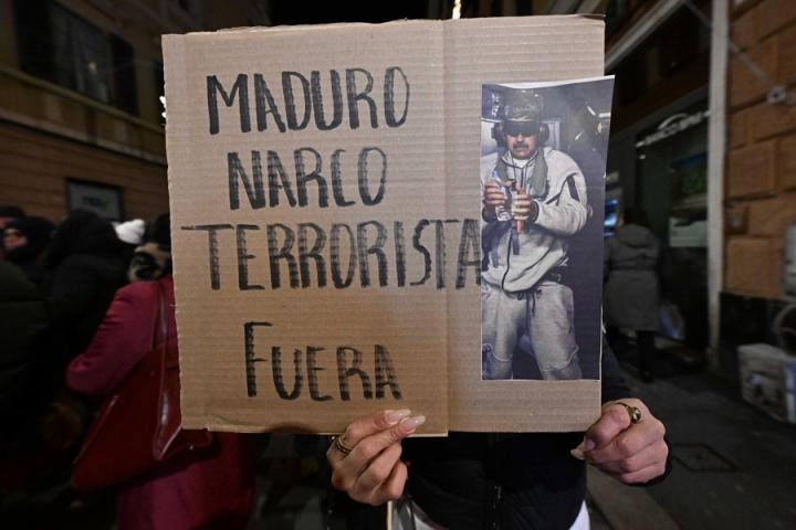 Una persona luce una pancarta celebrando la captura de Maduro, durante una manifestación