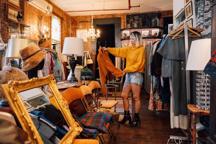 Una mujer mirando artículos en una tienda de segunda mano.