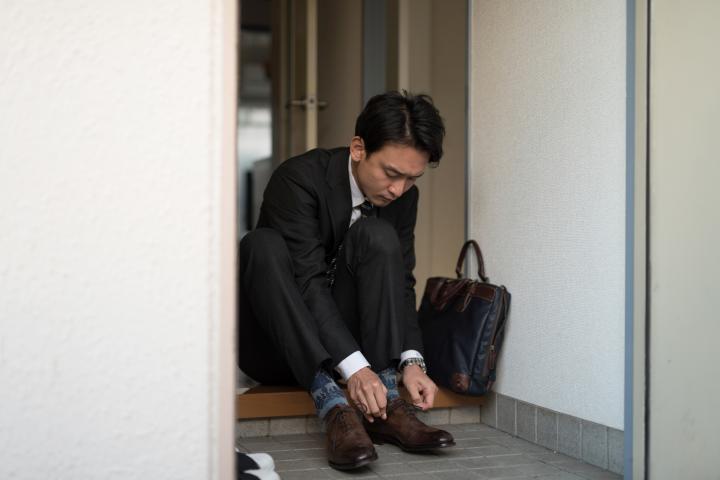 Un hombre japonés quitándose los zapatos en casa.