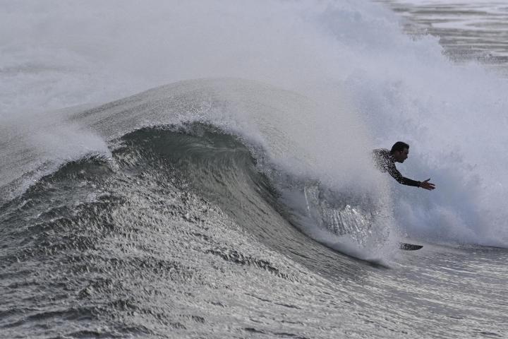 Una persona practica surf en una playa de Asturias.