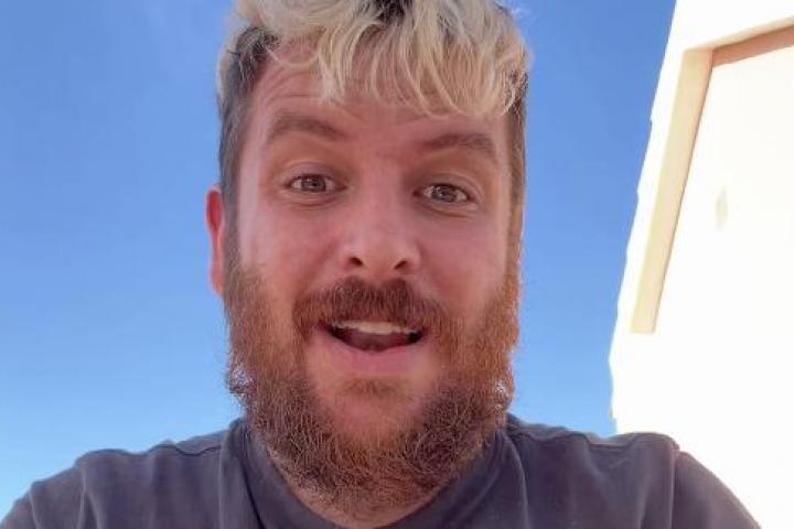 Hombre grabándose en primer plano para TikTok mientras reflexiona sobre la experiencia de criar a su hijo en España.