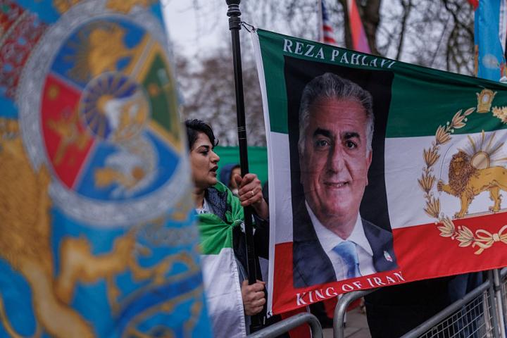 Manifestantes ondean banderas que del príncipe heredero iraní en el exilio, Reza Pahlavi, frente a la Embajada de Irán, el 14 de enero de 2026, en Londres, (Reino Unido).