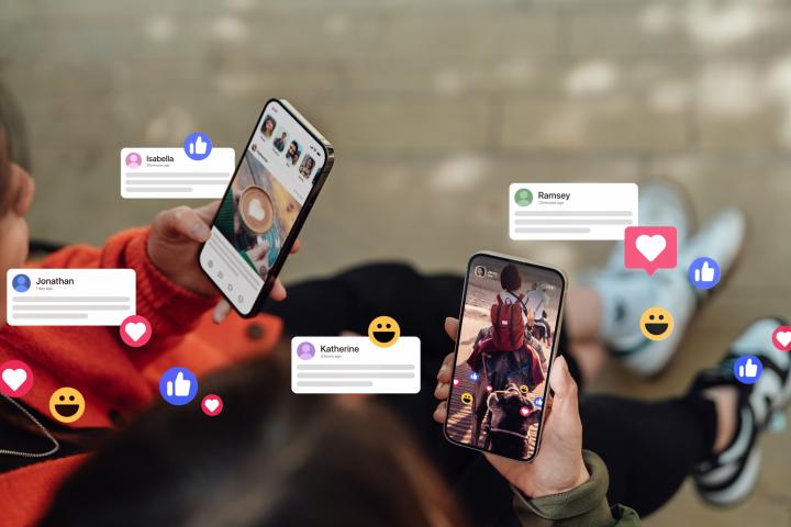 Dos manos femeninas sostienen sus smartphones, conectando con redes sociales, dejando comentarios, enviando mensajes y compartiendo fotos. La tecnología conecta a las personas.