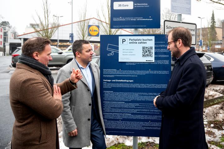 Un concejal de la zona coloca el cartel que autoriza el aparcamiento del Lidl como habilitado para todo el mundo