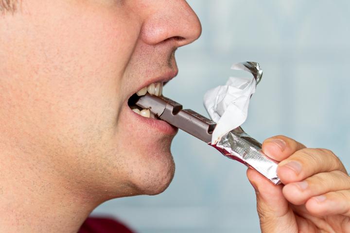 Un hombre comiendo una barrita de chocolate, en una imagen de archivo.
