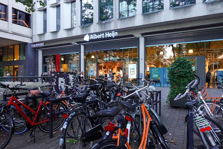 Aparcamiento de bicicleta delante de la entrada de un supermercado en Rotterdam.
